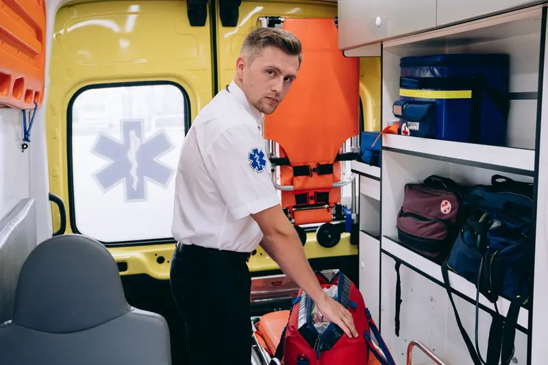 Paramedic preparing equipment inside an ambulance